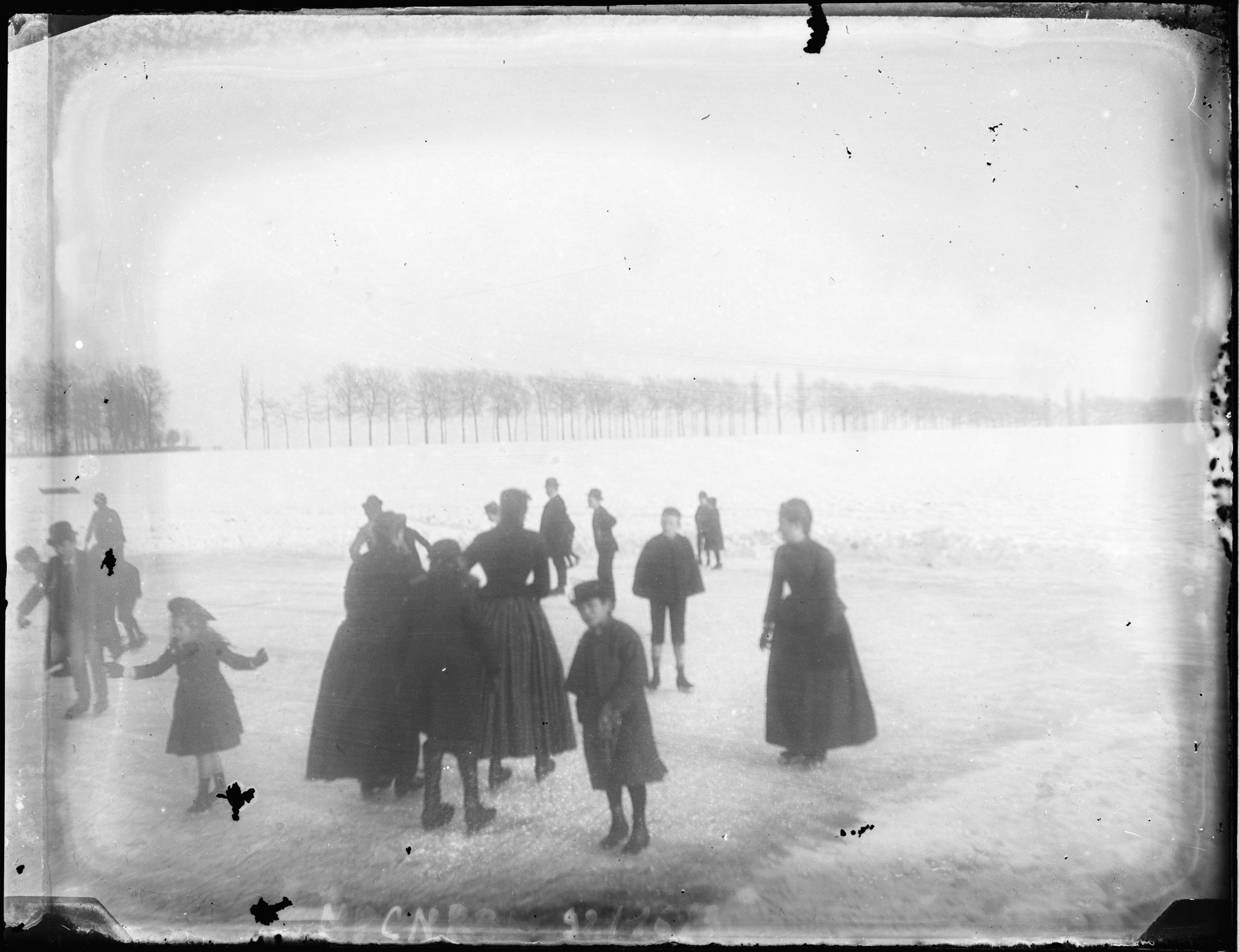 Groupe de femmes et d'enfants patinant sur un étang en hiver