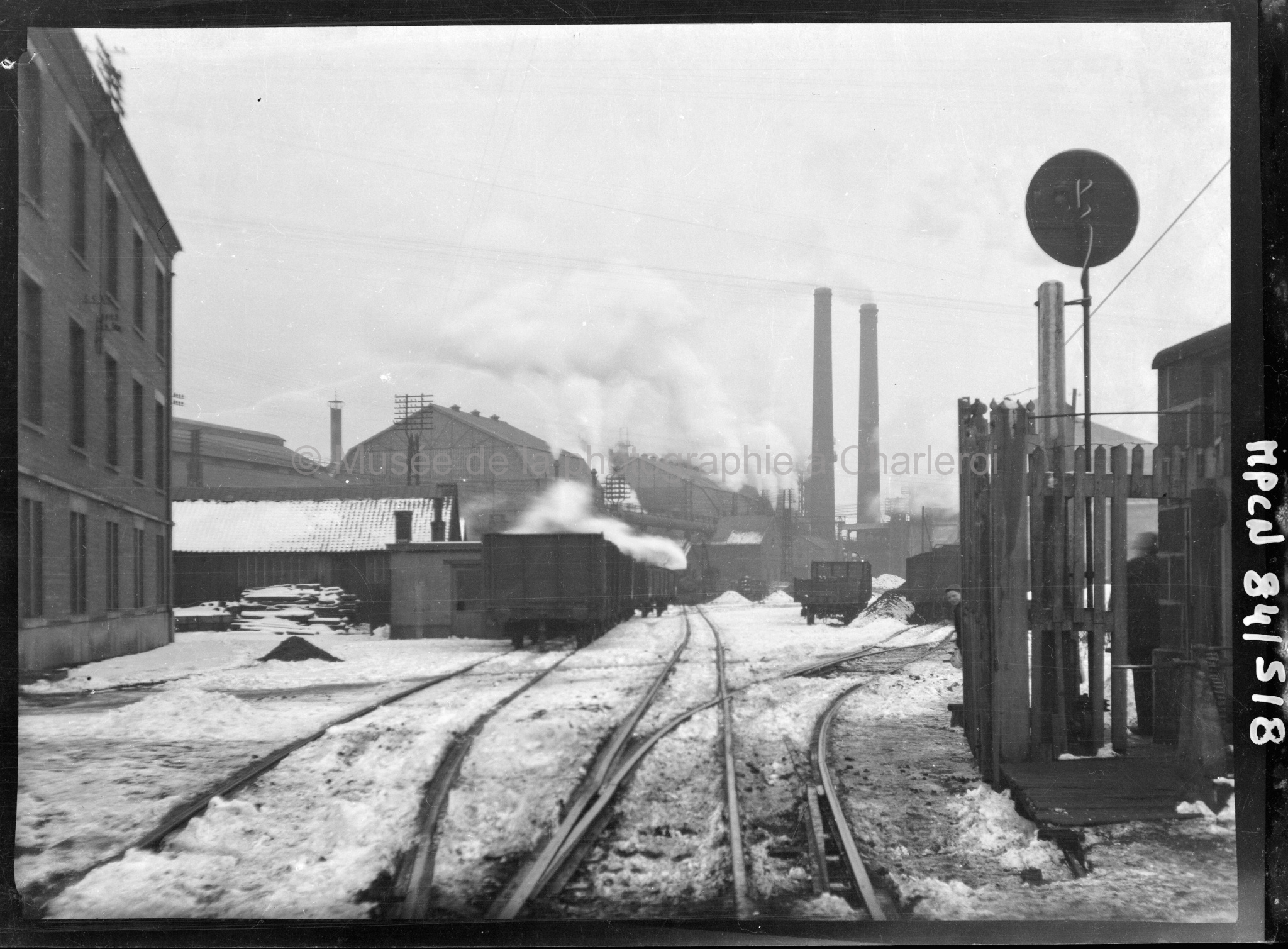 Entrée d'une usine avec rails, en hiver