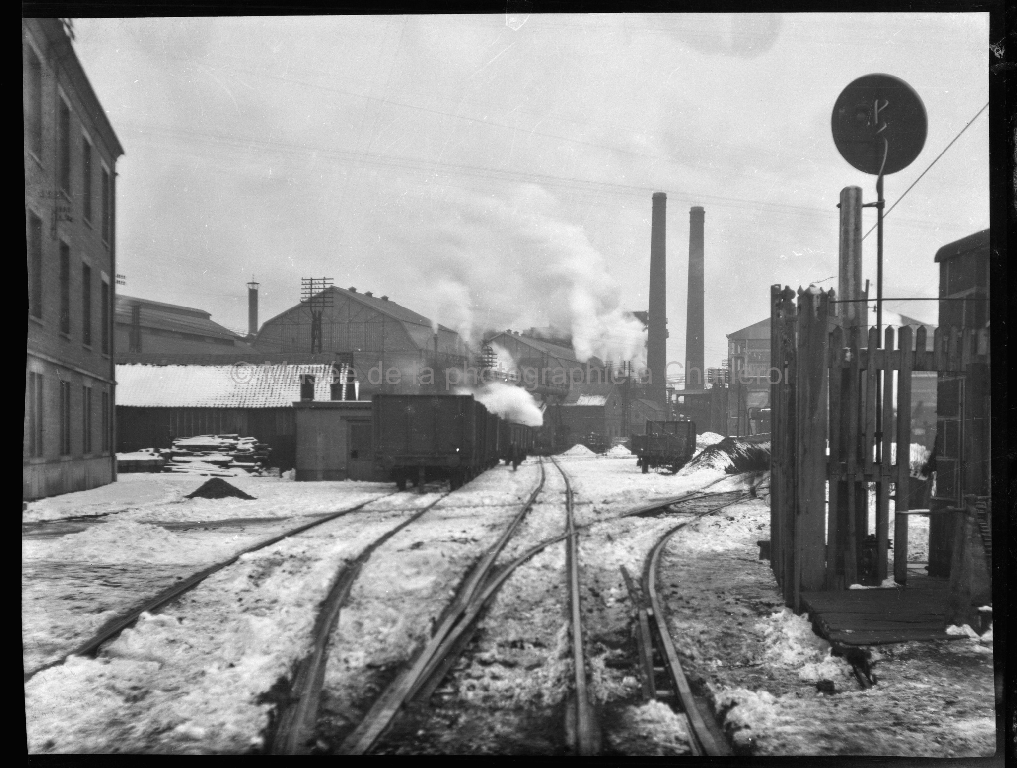 Entrée d'une usine avec rails, en hiver